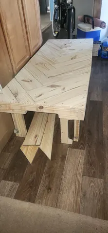 Trimming edges of custom herringbone wood tabletop flush with frame